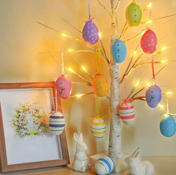 Easter decoration with lighted birch tree and colorful egg ornaments.
