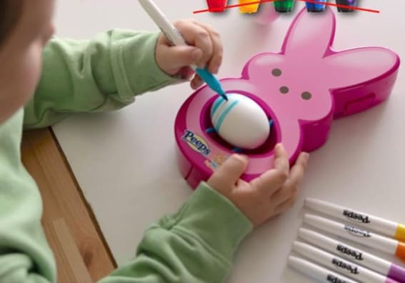  Child using The Eggmazing Easter Egg Decorator with Peeps Bunny design and colorful markers.