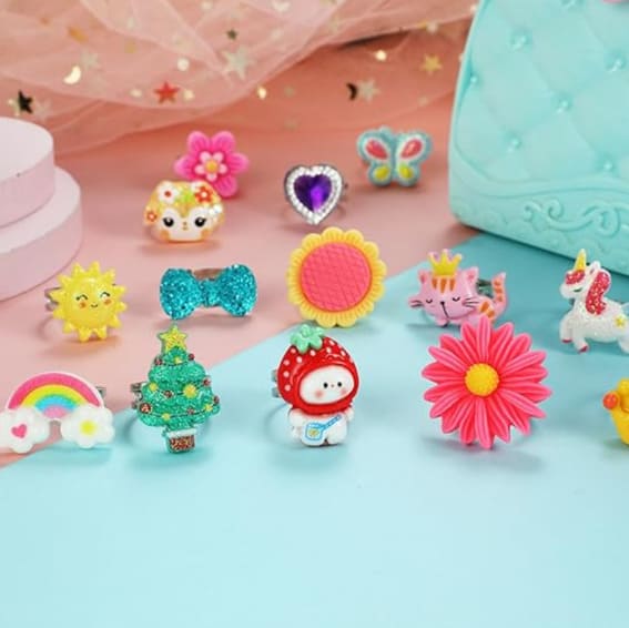 Assorted PinkSheep jewel rings in a box, colorful designs for little girls.