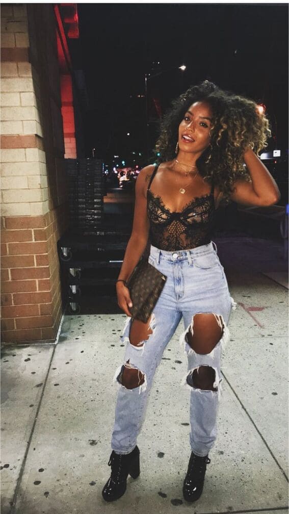 Woman in a lace bodysuit and ripped jeans ready for a summer night out.