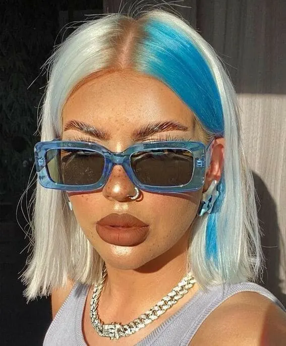 A woman wearing striking blue-tipped platinum hair.