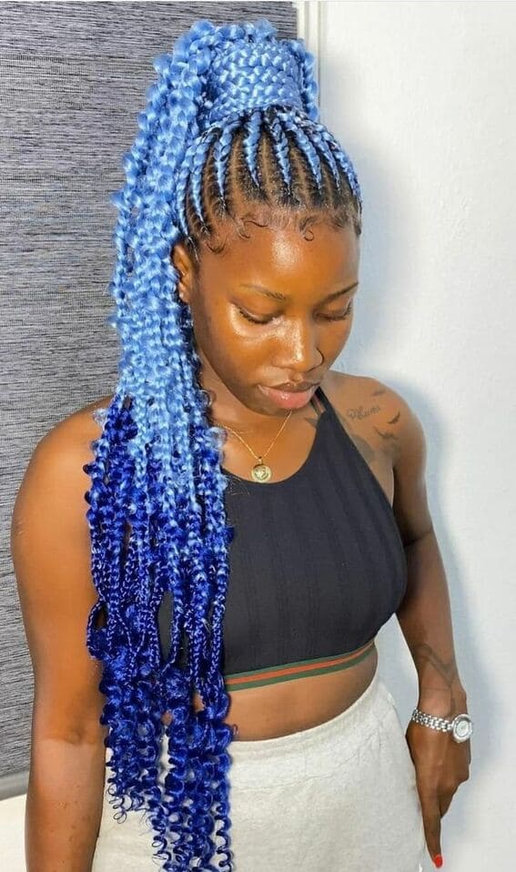 An elegant top bun is styled with vibrant blue braids.
