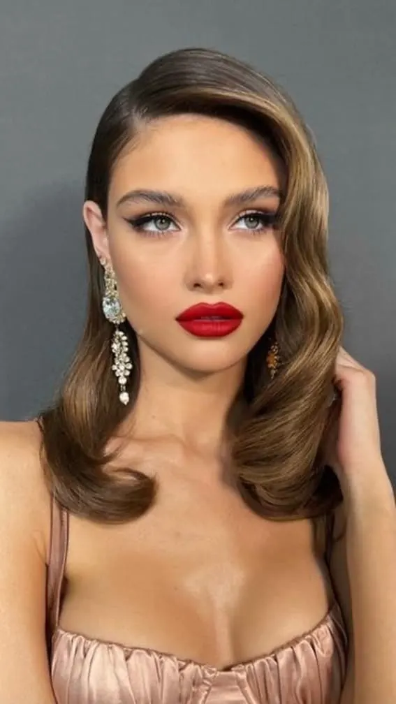 Glamorous woman with classic Hollywood curls and big lipstick.