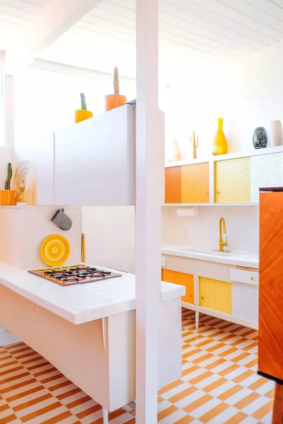 Bright and playful kitchen featuring orange cooktop, sunset gradient cabinets, and decorative items.