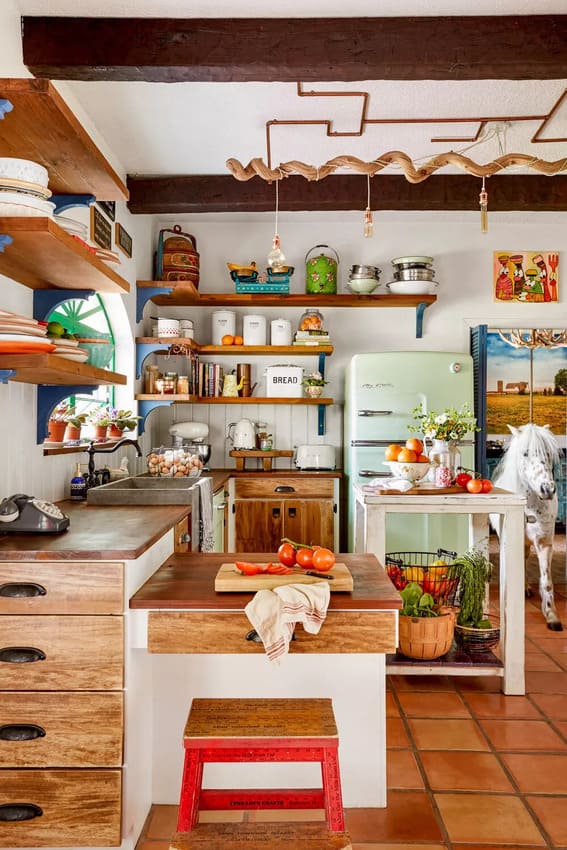 Rustic kitchen with open shelving displaying various orange accents.
