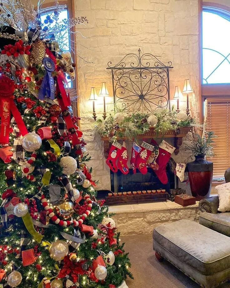 Ralph Lauren Christmas tree with buffalo check ribbon, prize rosettes, velvet bows, felt ball garland; stone fireplace with greenery and red stockings.