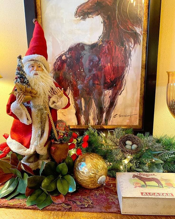 Ralph Lauren Christmas vignette—vintage Santa, bold equestrian horse art, magnolia leaves and cedar garland, gold ornament, bird nest, Alcazar horse box.