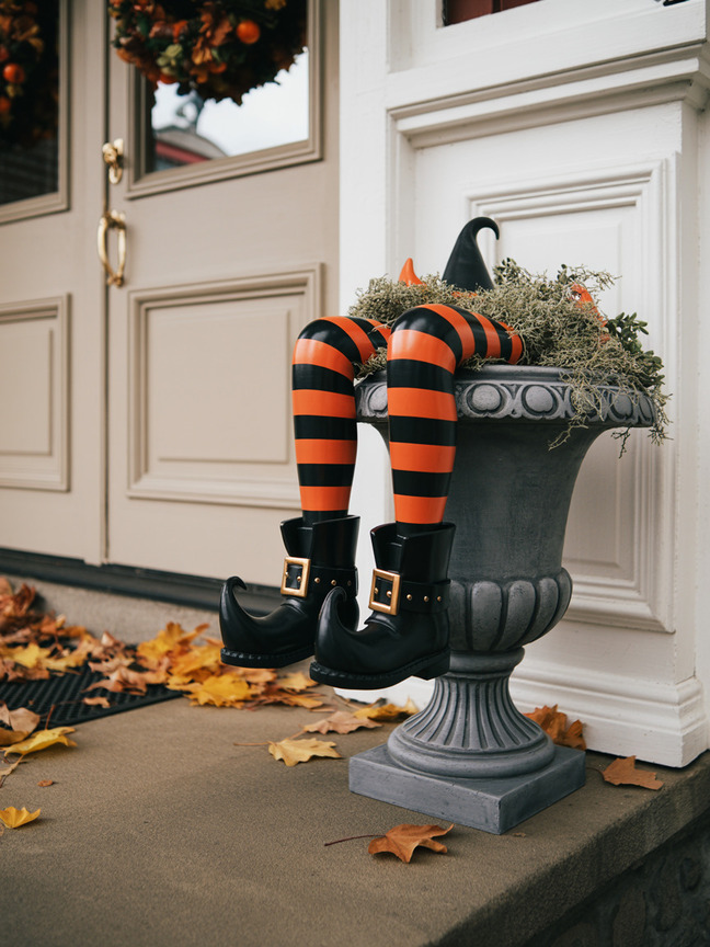 Vintage style Halloween porch planter with striped witch legs and black shoes