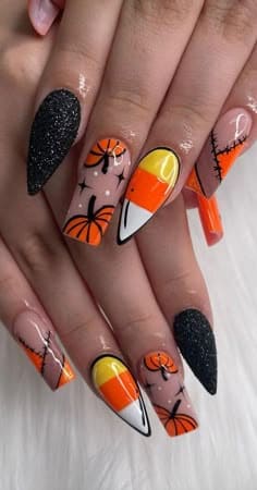 Halloween nails with candy corn design, black glitter nails, pumpkins, and stitched orange accents