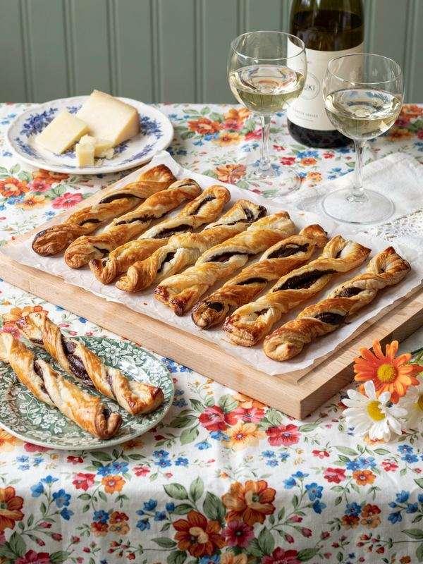 Chocolate puff pastry twists with white wine on a floral tablecloth