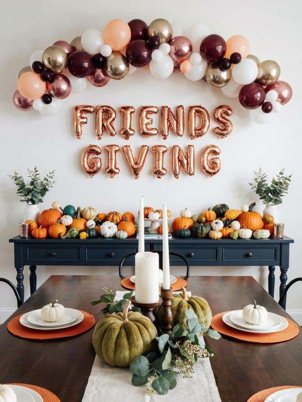 Friendsgiving dining room decorations with balloon garland and pumpkins