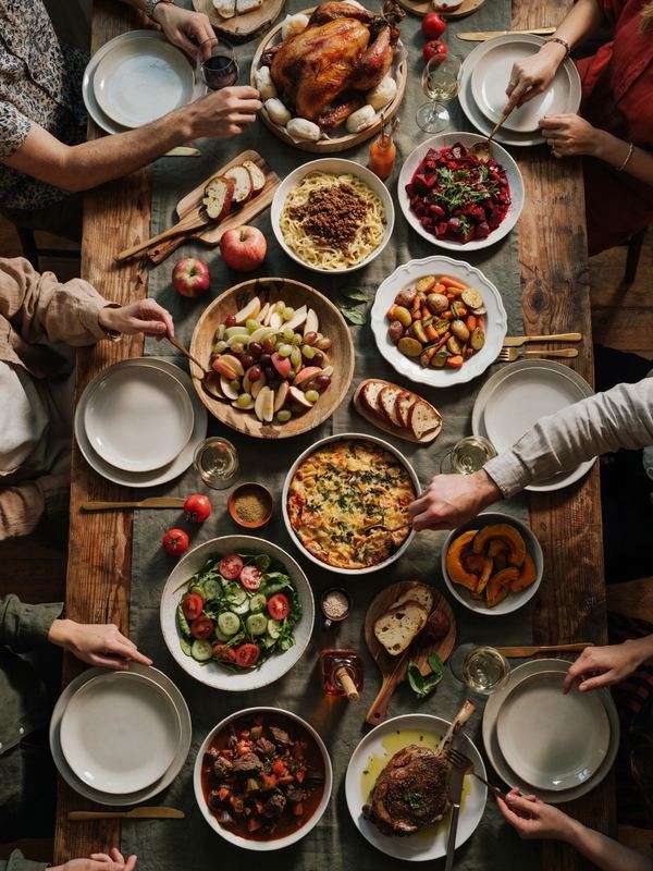 Friendsgiving dinner table with roast turkey and fall side dishes