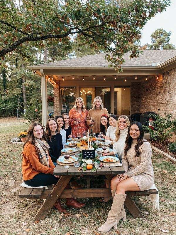 Friendsgiving dinner with friends around an outdoor picnic table