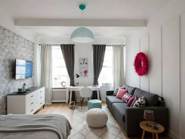 Long studio apartment layout with the bed sofa and desk arranged in separate zones