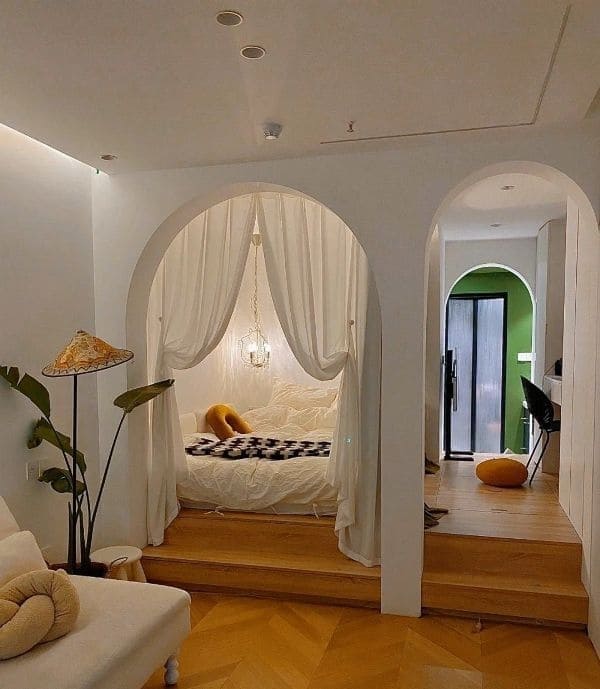 Studio apartment bedroom in an arched alcove with curtains for privacy