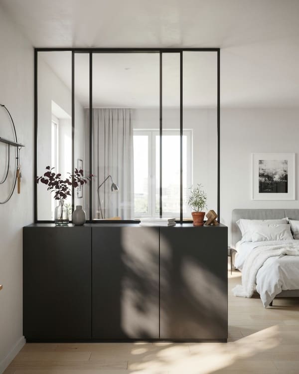 Studio apartment bedroom divided by glass panels and built-in storage