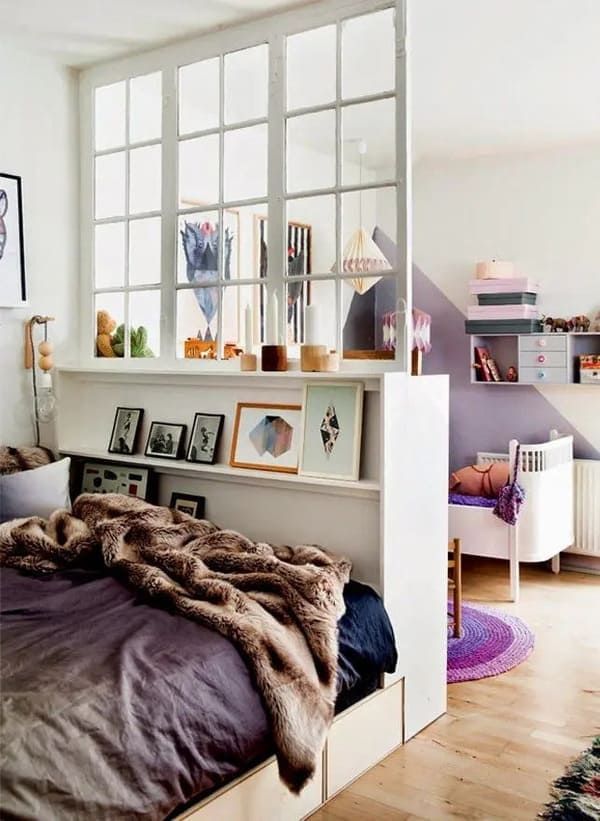 Window-style partition separating a studio apartment bedroom while allowing light through