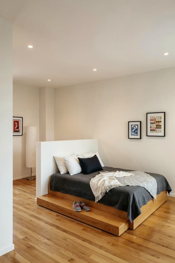 Raised bed platform separating the sleeping area in a studio apartment