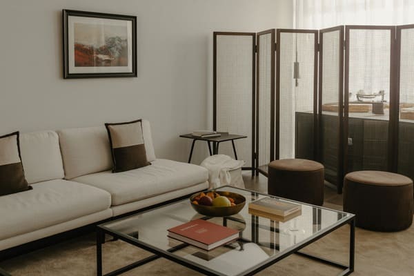 Studio apartment bed separated from the living room with a freestanding divider screen