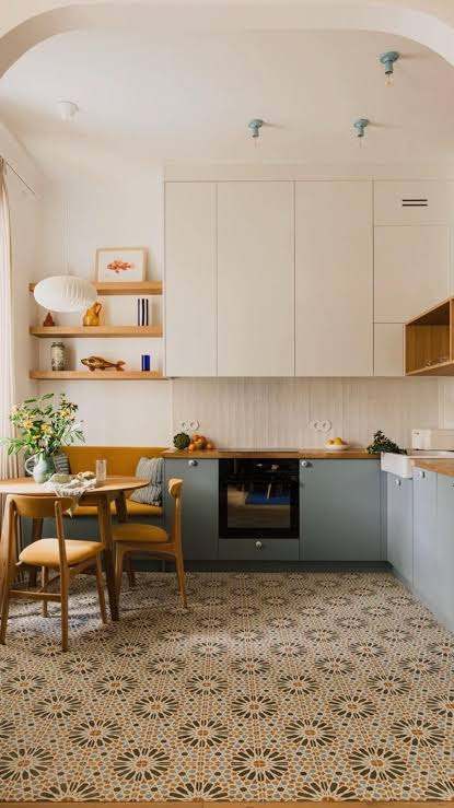 Compact apartment kitchen with patterned floor, dining table and built-in cabinets