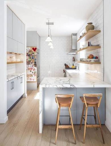 Small kitchen with marble peninsula, breakfast stools and open wall shelving