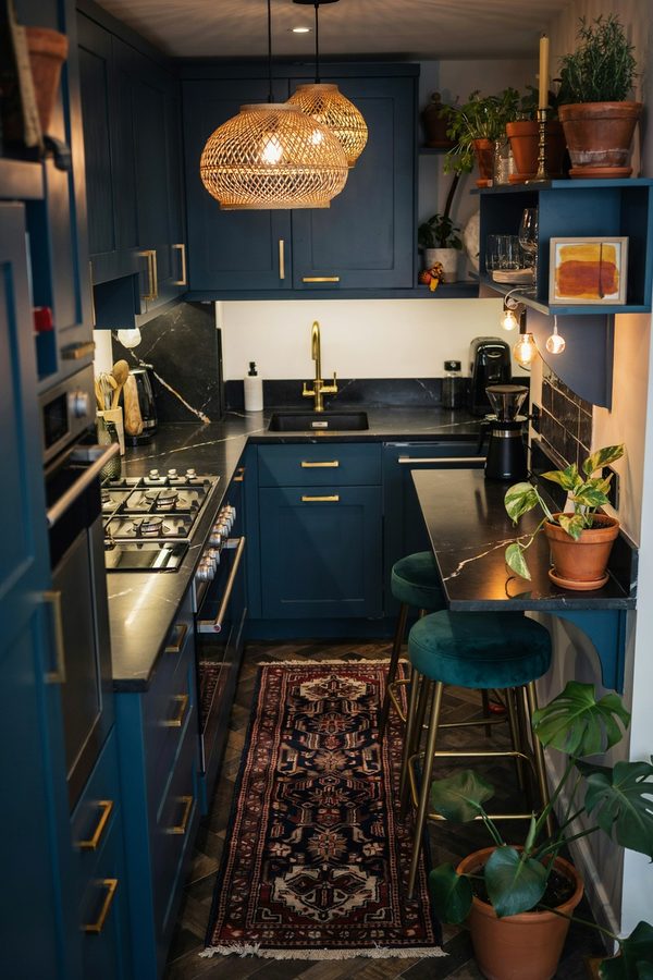 Narrow blue galley kitchen with rattan pendant lights and bar stools