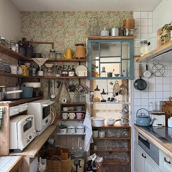 Small kitchen with crowded open shelves filled with household items